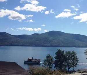 view of lake george with boat and mountains in background
