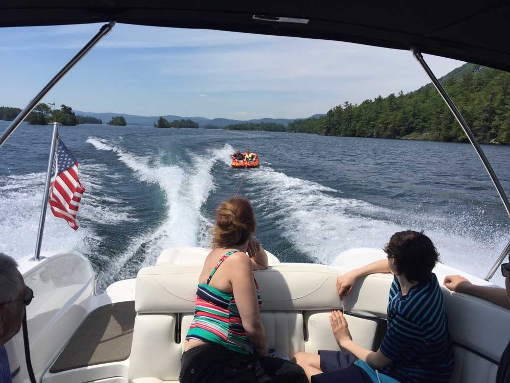two people on boat watching friends tubing