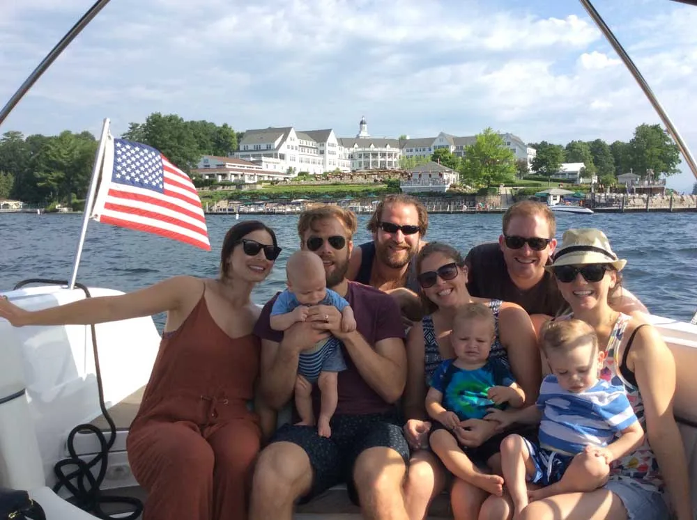 friends and family smiling for group photo on boat