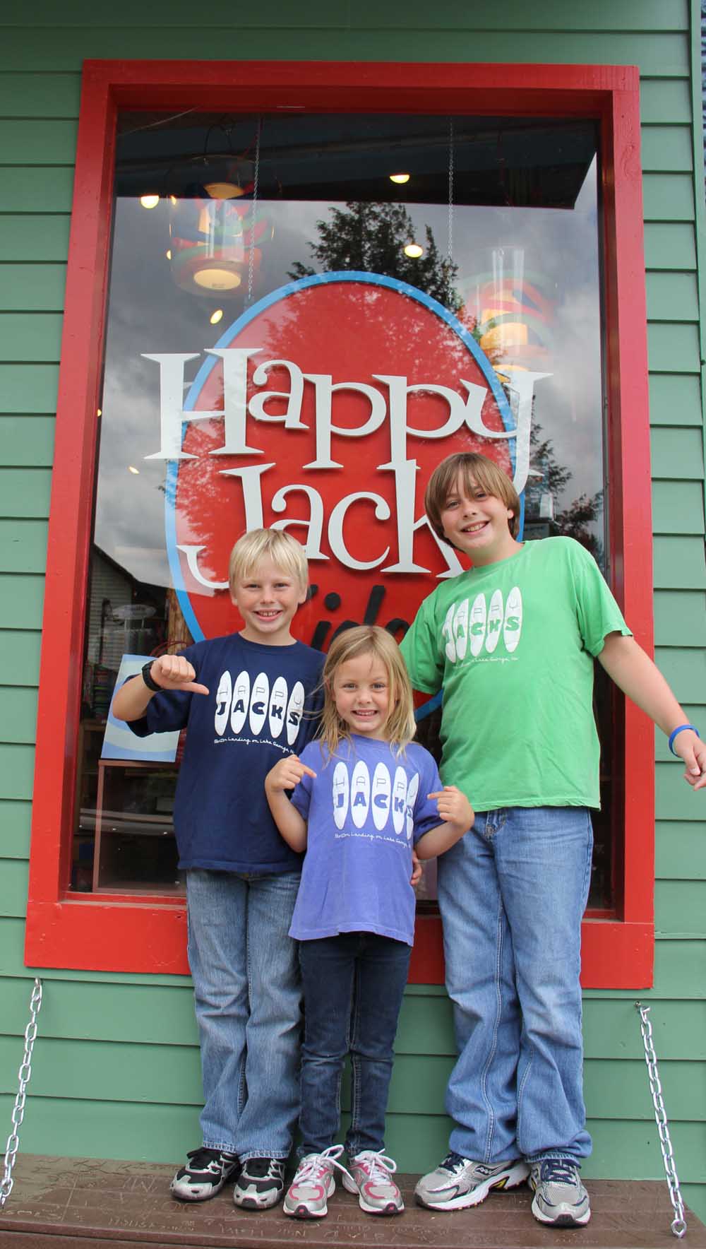 three children posing outside happy jacks window
